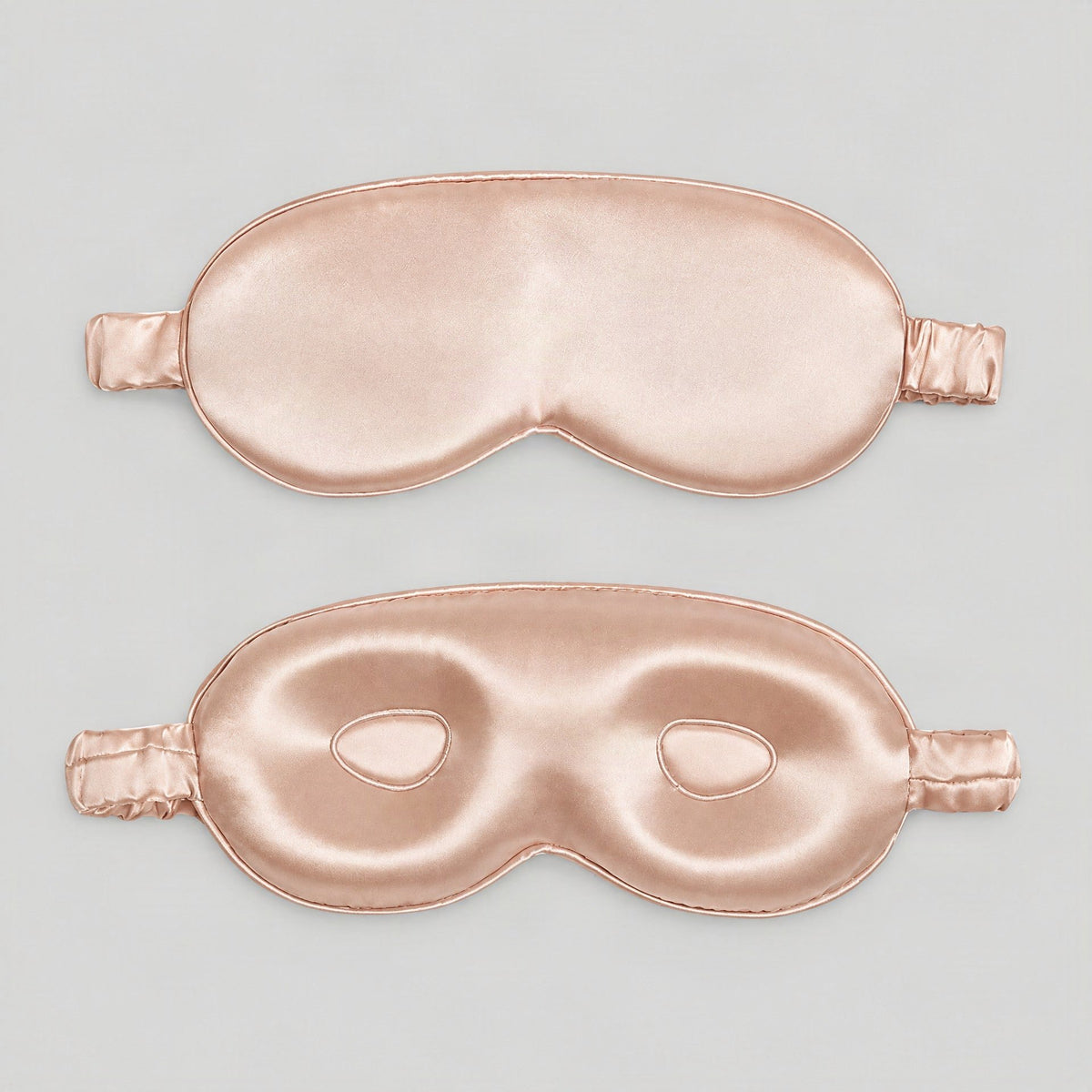 Lifestyle shot of the 19 Momme Mulberry Silk Sleep Eye Mask in soft gray, draped on a bed with natural light