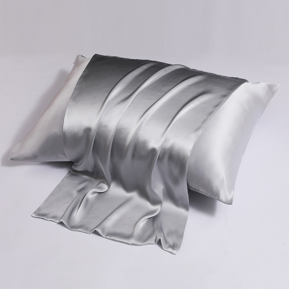 A pair of pink satin pillowcases, one partially draped over the other, against a white background, showing the smooth lustrous finish.