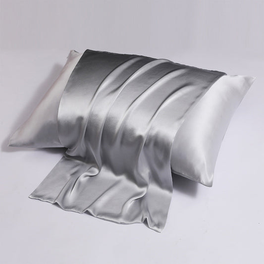 A pair of pink satin pillowcases, one partially draped over the other, against a white background, showing the smooth lustrous finish.