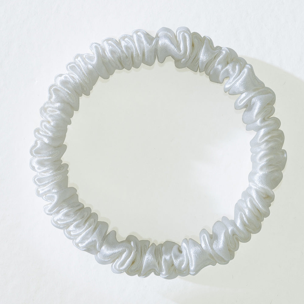 Close-up of a mulberry silk hair tie laid flat to show width and seam construction.