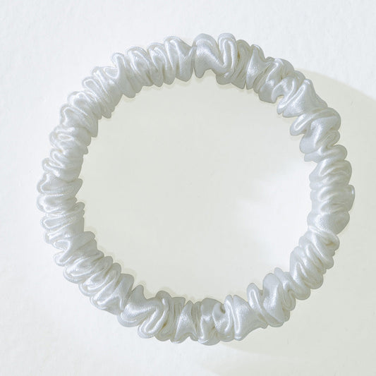 Close-up of a mulberry silk hair tie laid flat to show width and seam construction.