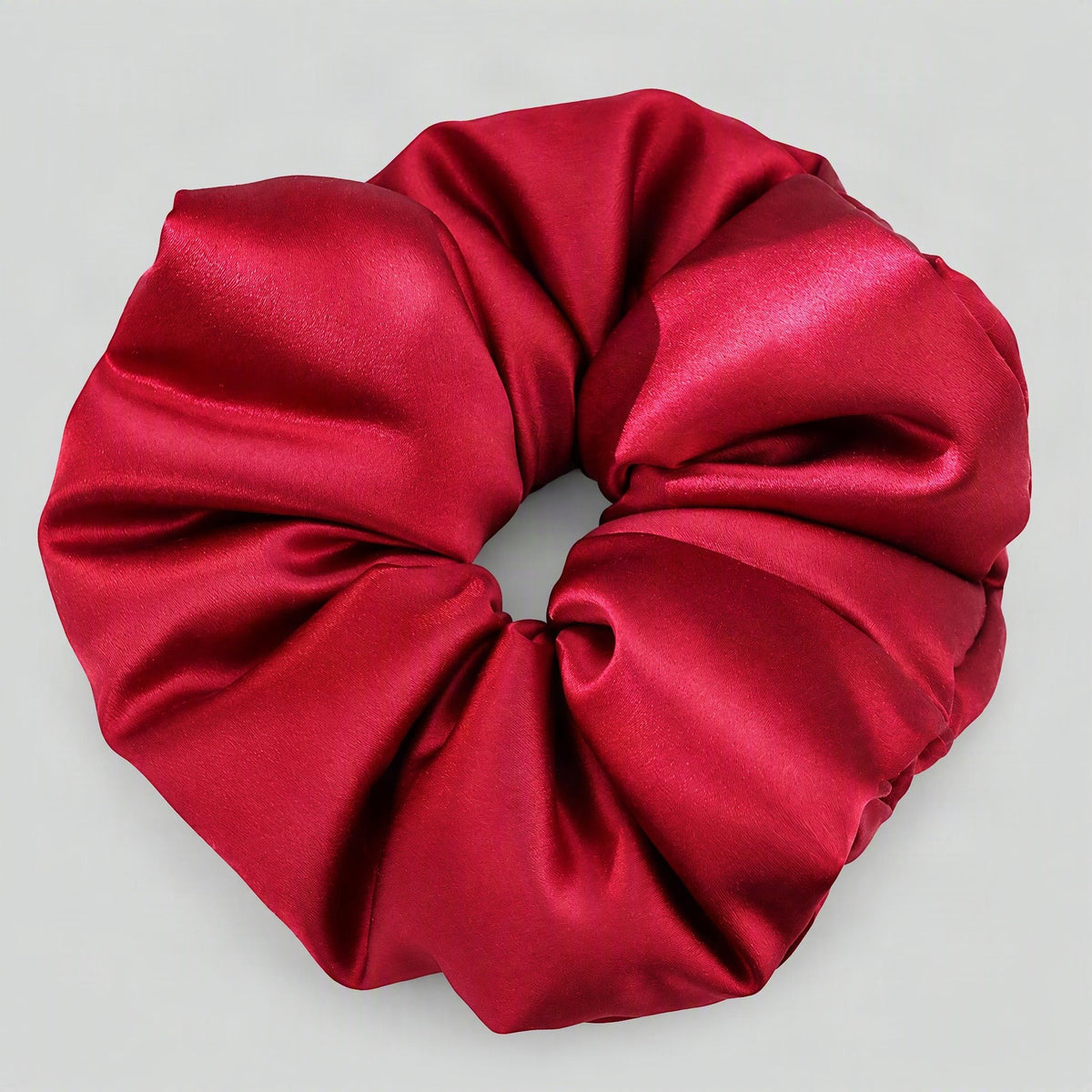 SuuSilk 30 momme mulberry silk padded scrunchie in soft blush pink, resting on a clean white surface.