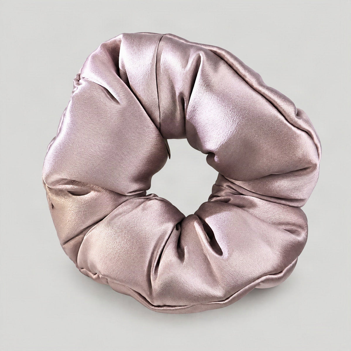 SuuSilk 30 Momme mulberry silk padded scrunchie in soft beige resting on a marble surface, showcasing its gentle, luxurious t