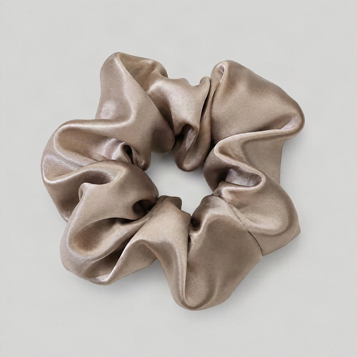 SuuSilk 100% mulberry silk scrunchie in soft blush tone resting on a light marble surface for everyday hair wear.