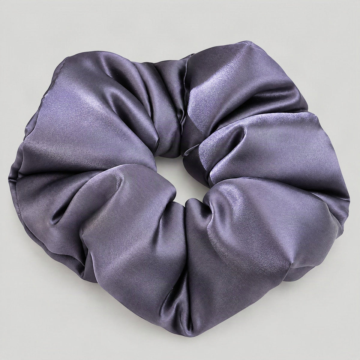 SuuSilk 30 Momme padded mulberry silk scrunchie in soft beige, styled on a marble surface for everyday wear.