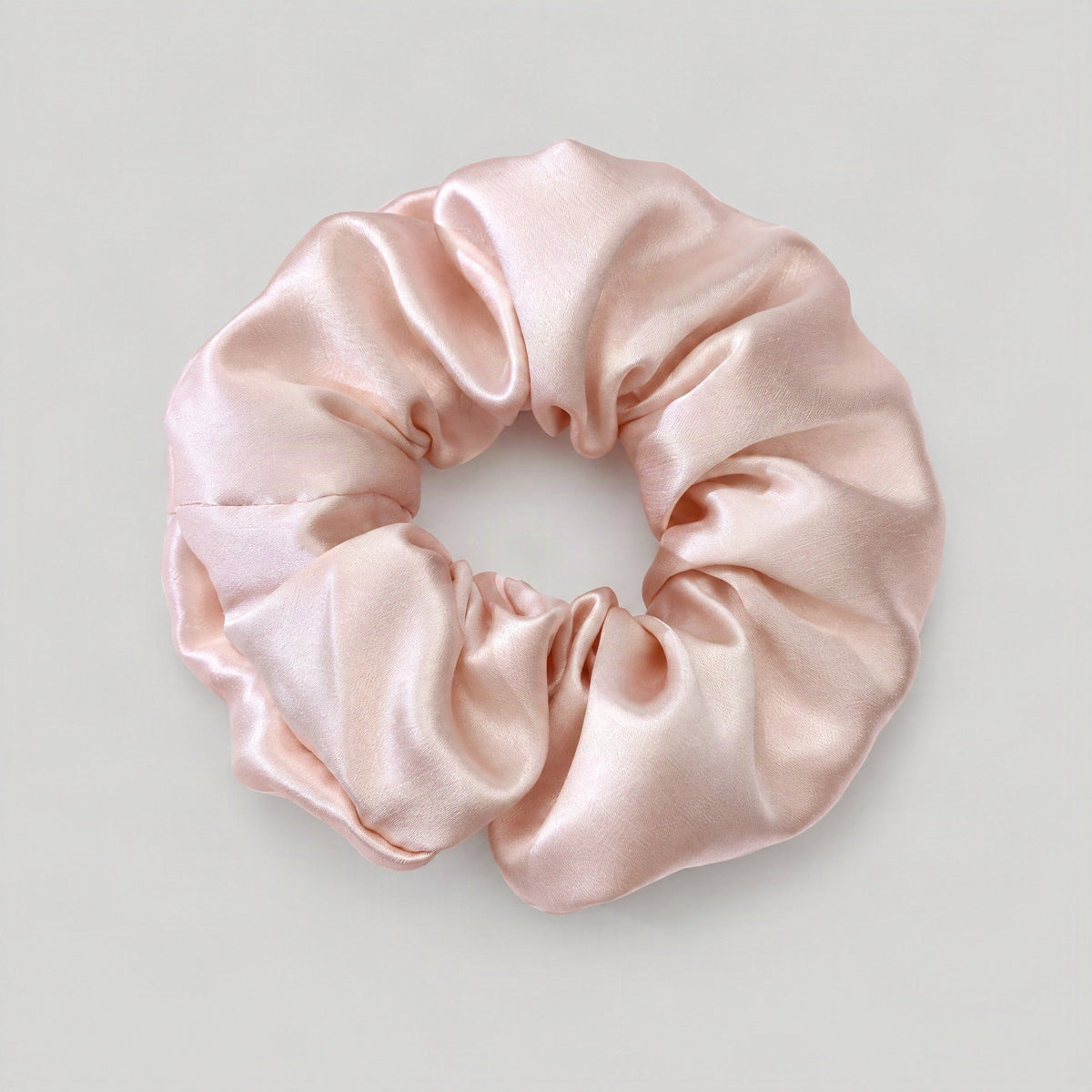 Mulberry silk scrunchie in a soft hue, gently holding hair for everyday elegant wear