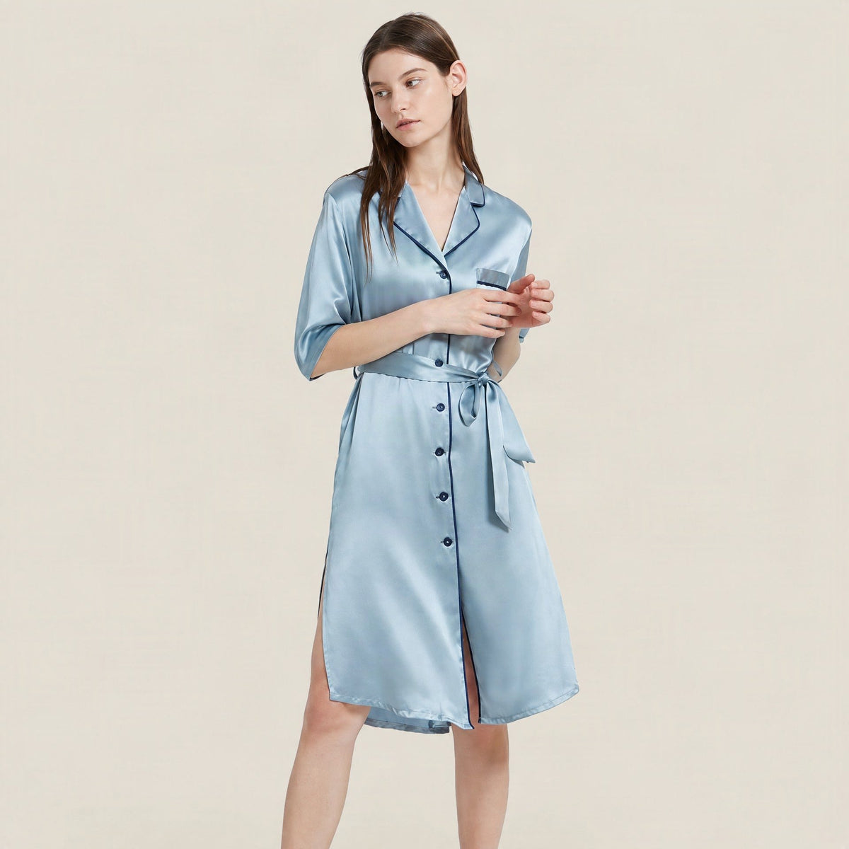 Powder blue 19 momme mulberry silk short-sleeve nightgown with navy piping and a tie belt, worn by a model