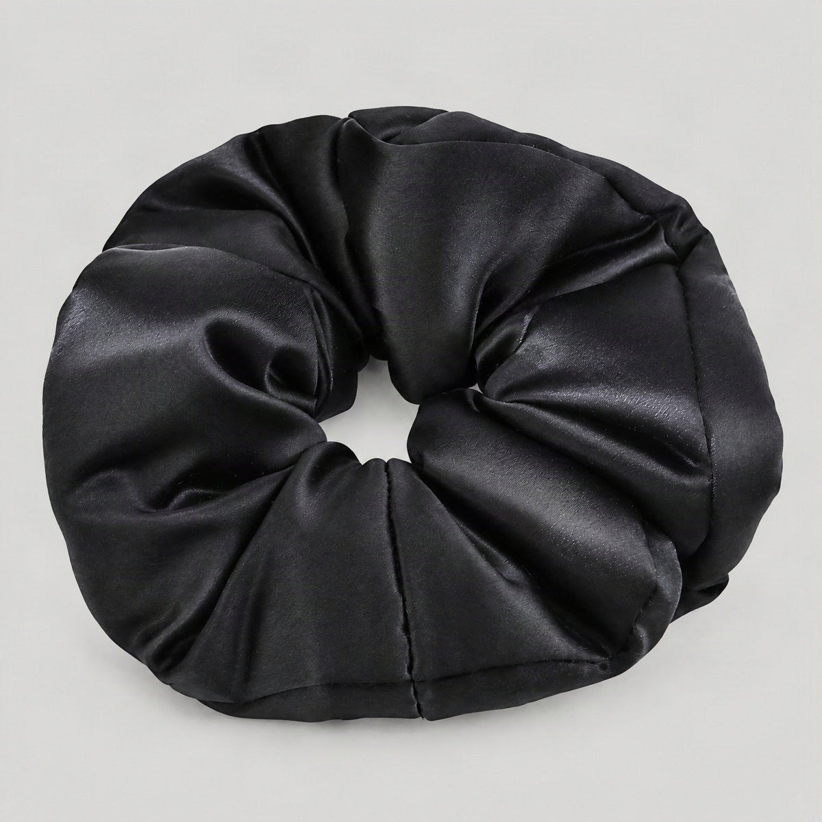 Close-up of SuuSilk 30 Momme Mulberry Silk Scrunchie in champagne gold, highlighting padded texture and soft sheen on neutral
