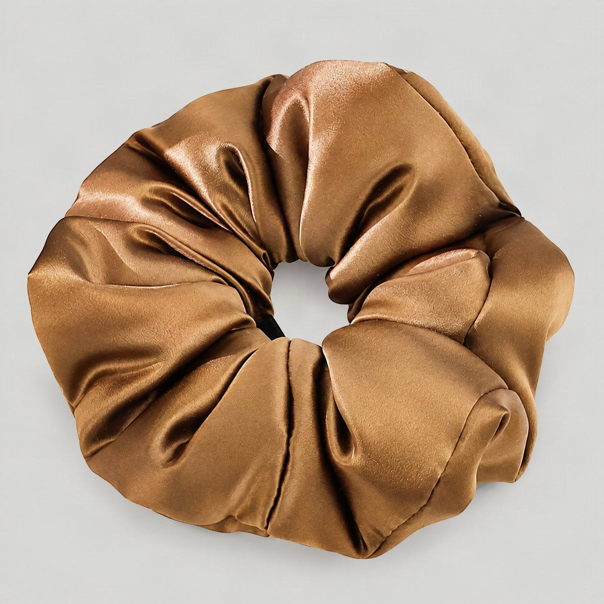 SuuSilk 30 Momme padded mulberry silk scrunchie in soft cream resting on a marble surface, showcasing gentle everyday hair ca