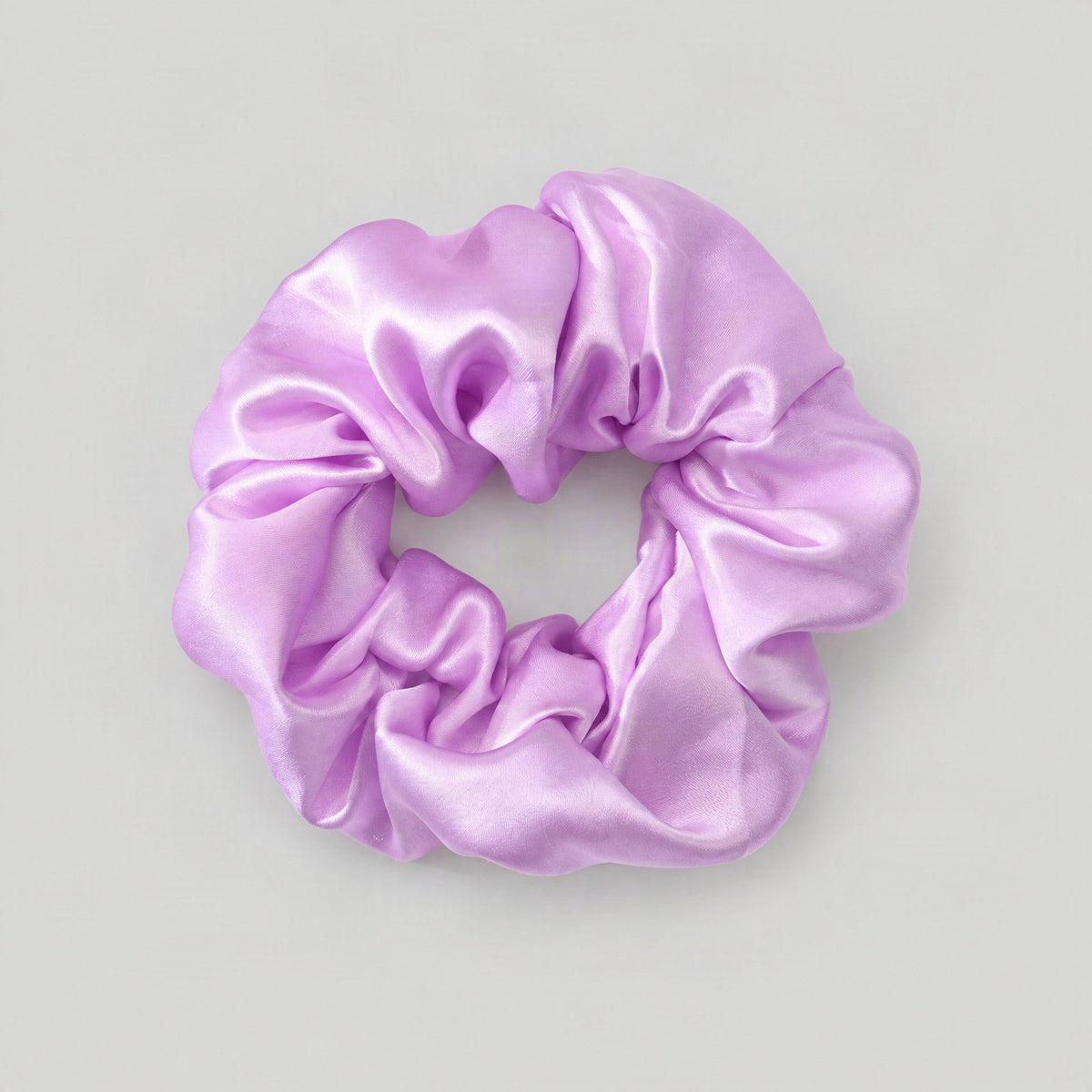 SuuSilk mulberry silk scrunchie in soft pastel color, gently resting on a smooth surface for everyday hair wear