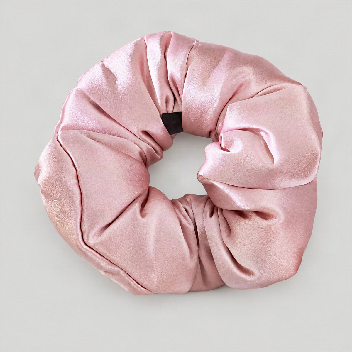 SuuSilk 30 Momme mulberry silk scrunchie in ivory, shown styled on a wrist with soft natural lighting highlighting its plush 