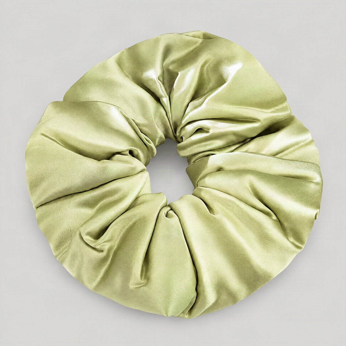 SuuSilk 30 Momme mulberry silk scrunchie in soft blush pink, gently holding a loose ponytail on a marble surface