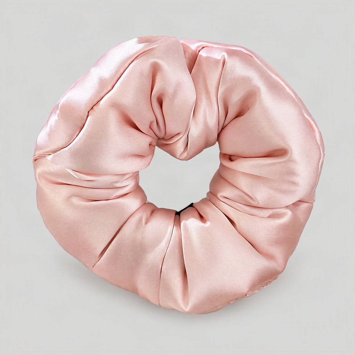Soft white 30 Momme mulberry silk scrunchie with padding displayed on a marble surface, showcasing its smooth sheen and hair-