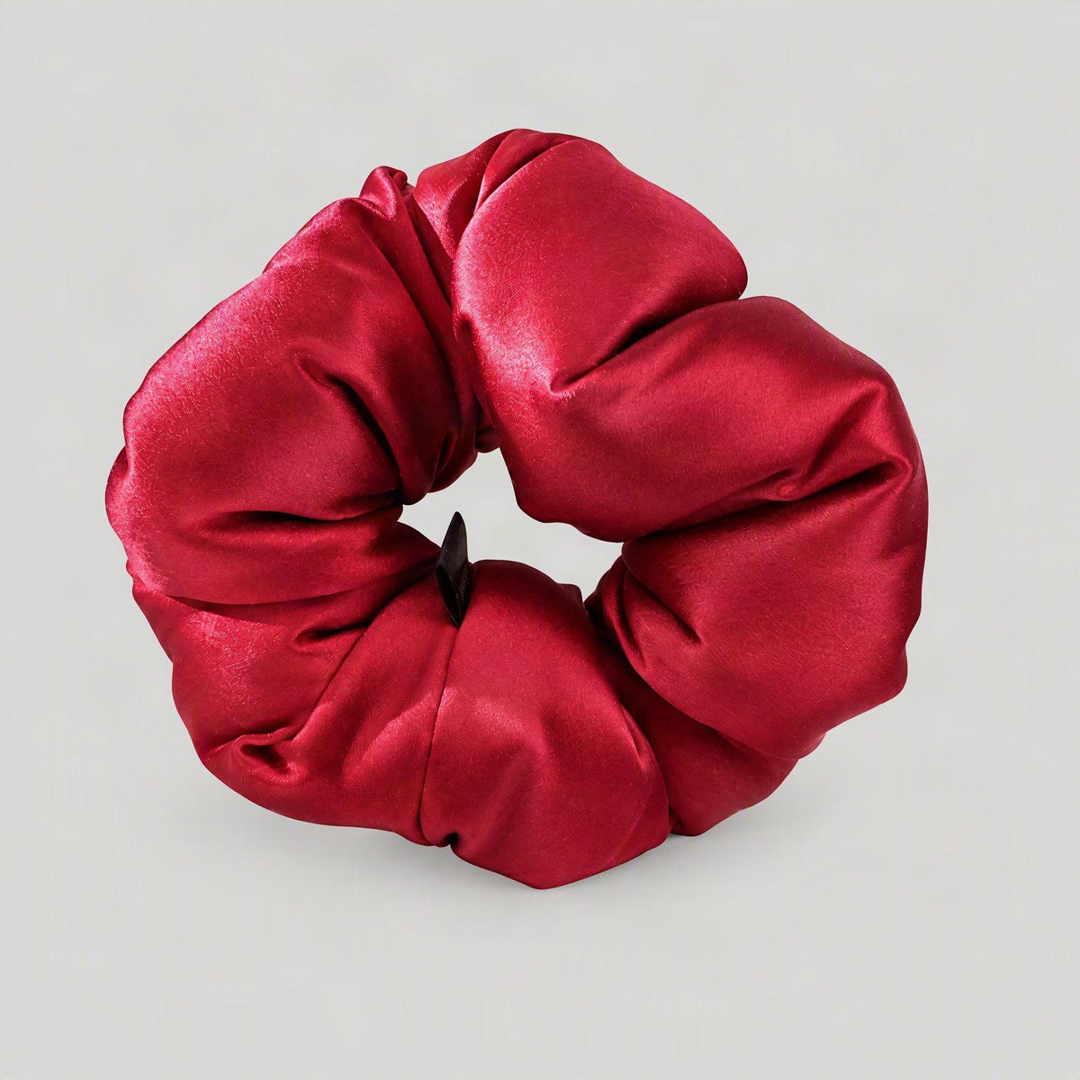 SuuSilk 30 Momme mulberry silk scrunchie in soft blush pink, gently scrunched on a marble surface