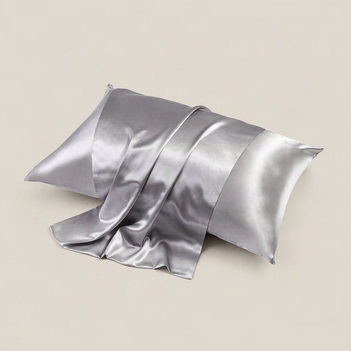 SuuSilk 22 Momme glossy mulberry silk pillowcase in dusty pink shown draped softly on a styled bed with natural light
