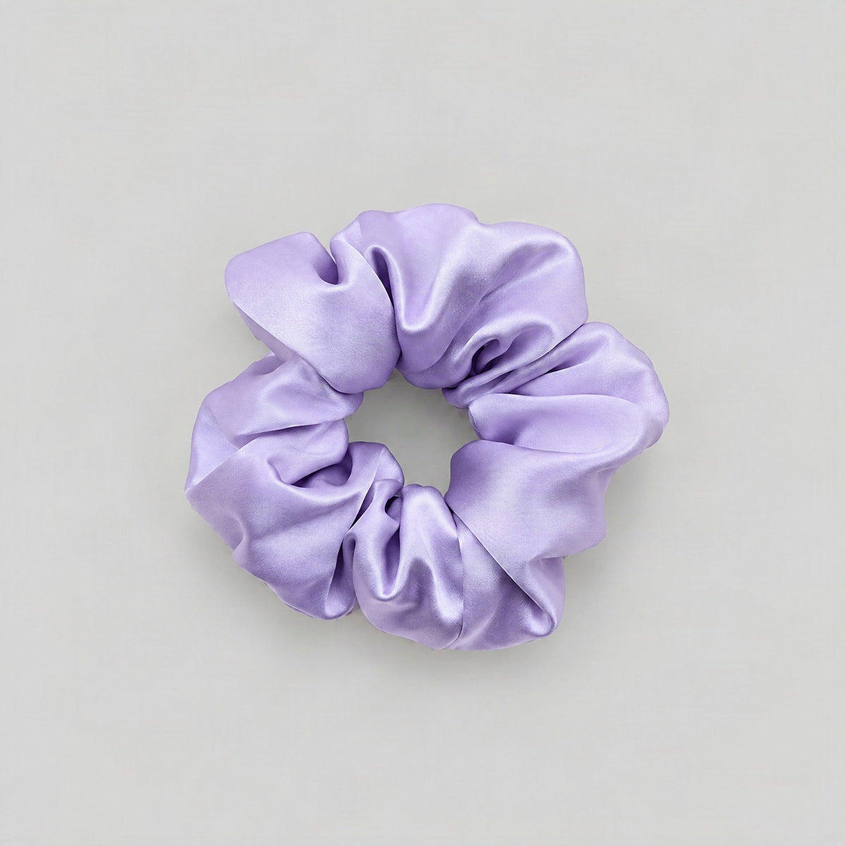 SuuSilk 30 Momme mulberry silk scrunchie in soft neutral tone, styled on a marble surface for everyday hair care