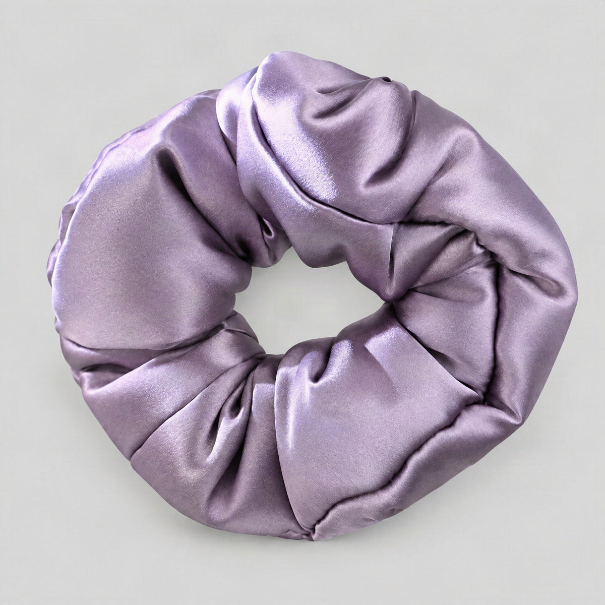 SuuSilk 30 Momme Mulberry silk padded scrunchie in soft pink resting on a marble surface, gentle hair accessory for everyday 