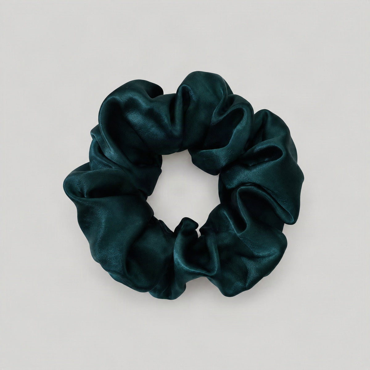 SuuSilk mulberry silk scrunchie in soft pastel pink, gently wrapped around a wrist on a clean white surface