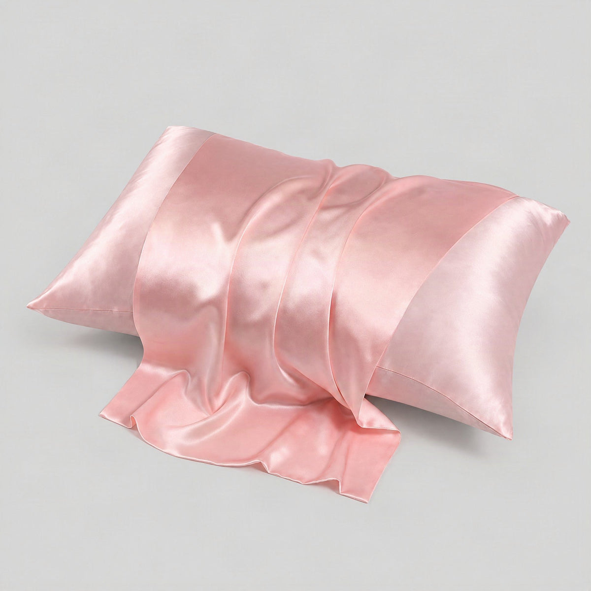 Gray matte silk envelope pillowcase with hidden closure draped on a bed, showcasing luxurious 22 momme mulberry silk texture 