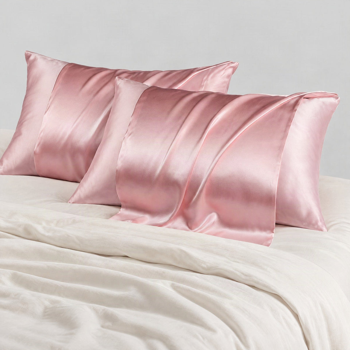 Glossy white 22 momme silk envelope pillowcase neatly arranged on a bed with hidden closure detail visible