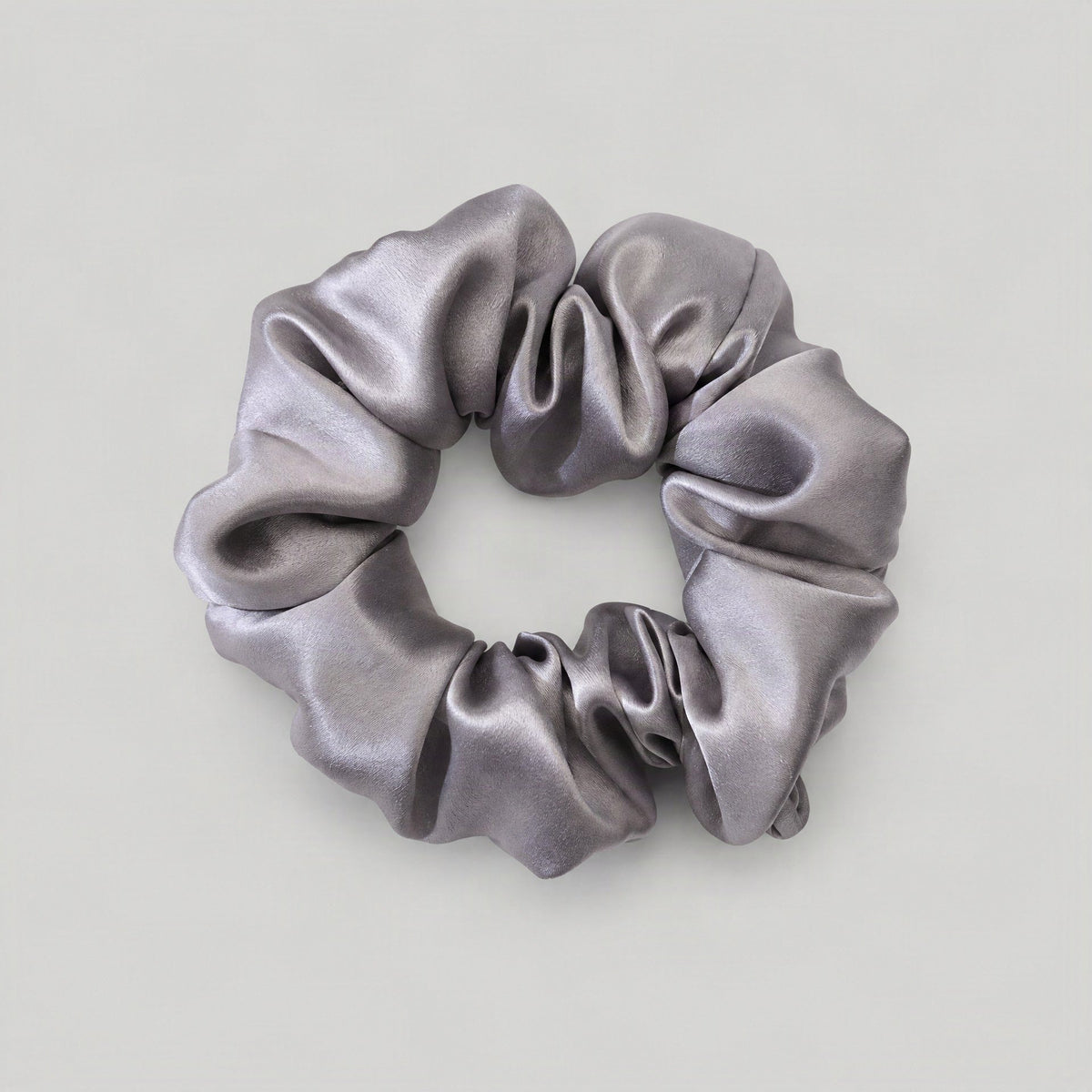 SuuSilk mulberry silk scrunchie in soft blush, draped on a marble surface with morning light
