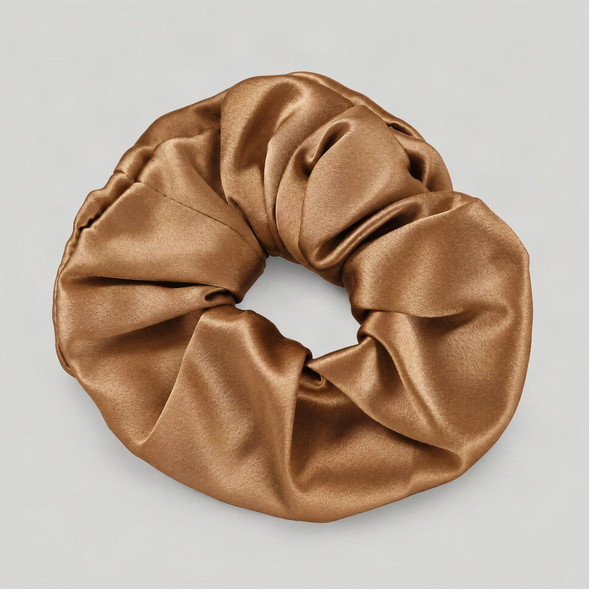 SuuSilk 30 Momme mulberry silk scrunchie in soft beige, gently holding hair in a natural lifestyle setting