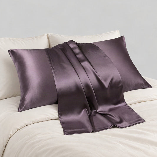 Soft champagne-colored SuuSilk mulberry silk pillowcase with hidden zipper rests on neutral linen bedding in a cozy bedroom s
