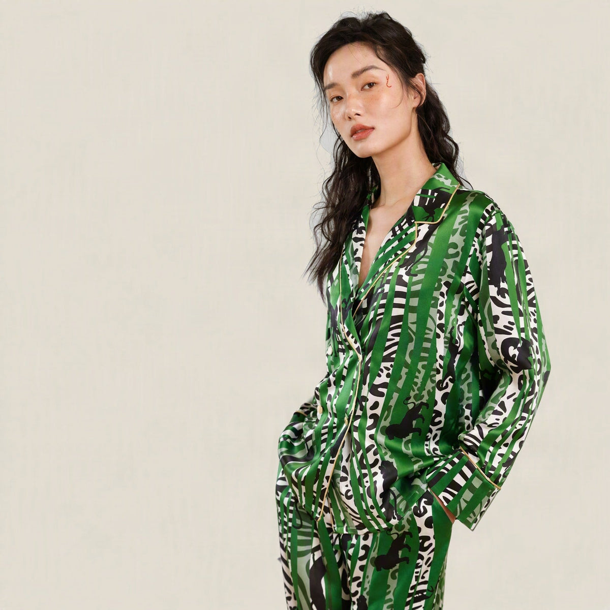 Green and black Oasis-print 19 momme mulberry silk long-sleeve pajama set with gold piping, worn by a model