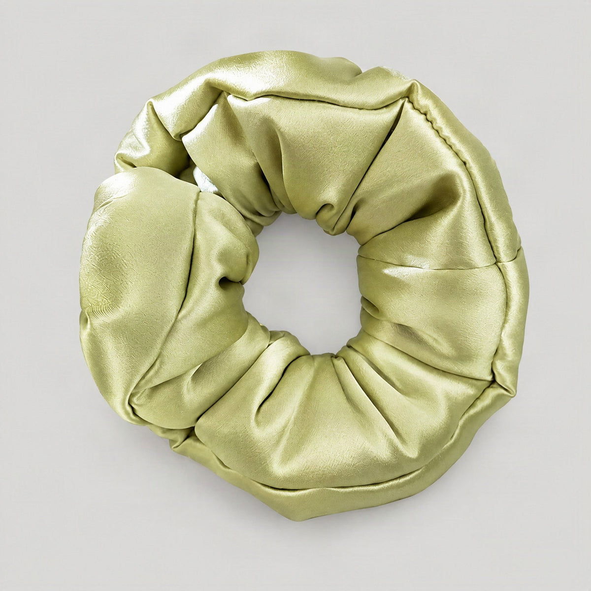 uSilk 30 Momme mulberry silk scrunchie in soft neutral tone, gently scrunched on a marble surface with natural lighting