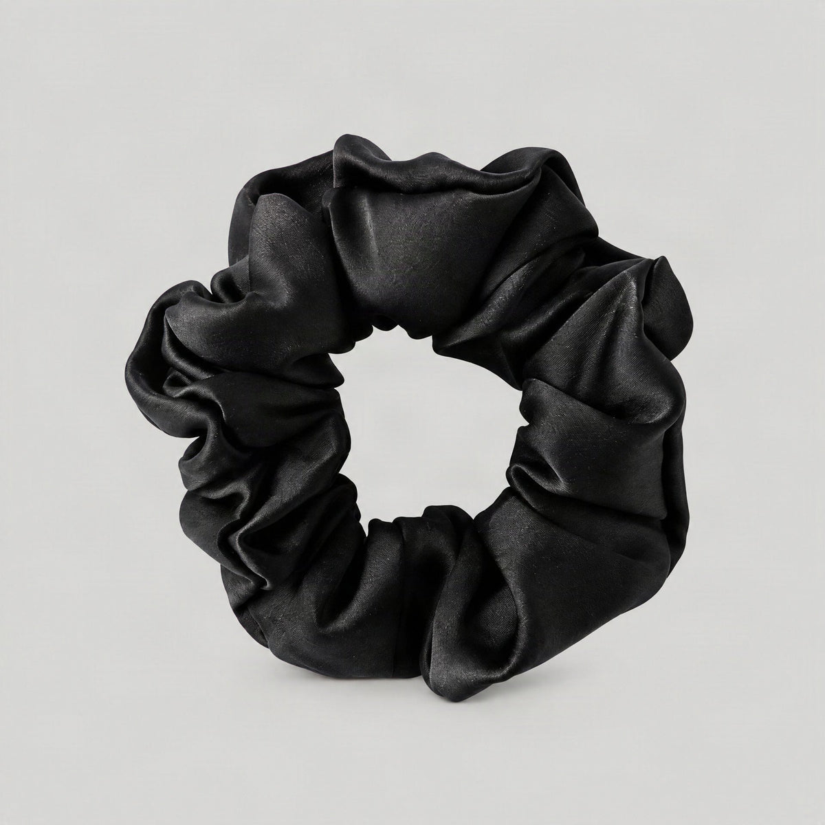 SuuSilk 16 Momme ruffled mulberry silk scrunchie in soft beige, elegantly styled on a marble surface with delicate florals ne