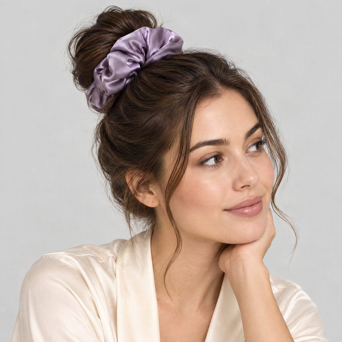 SuuSilk 30 Momme padded mulberry silk scrunchie in soft blush tone, displayed on a marble vanity beside skincare bottles
