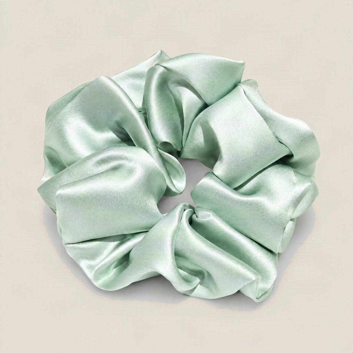 SuuSilk 30 Momme mulberry silk scrunchie in soft champagne color on white background, showing smooth lustrous texture