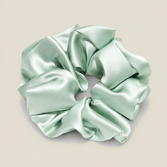 SuuSilk 30 Momme mulberry silk scrunchie in soft champagne color on white background, showing smooth lustrous texture