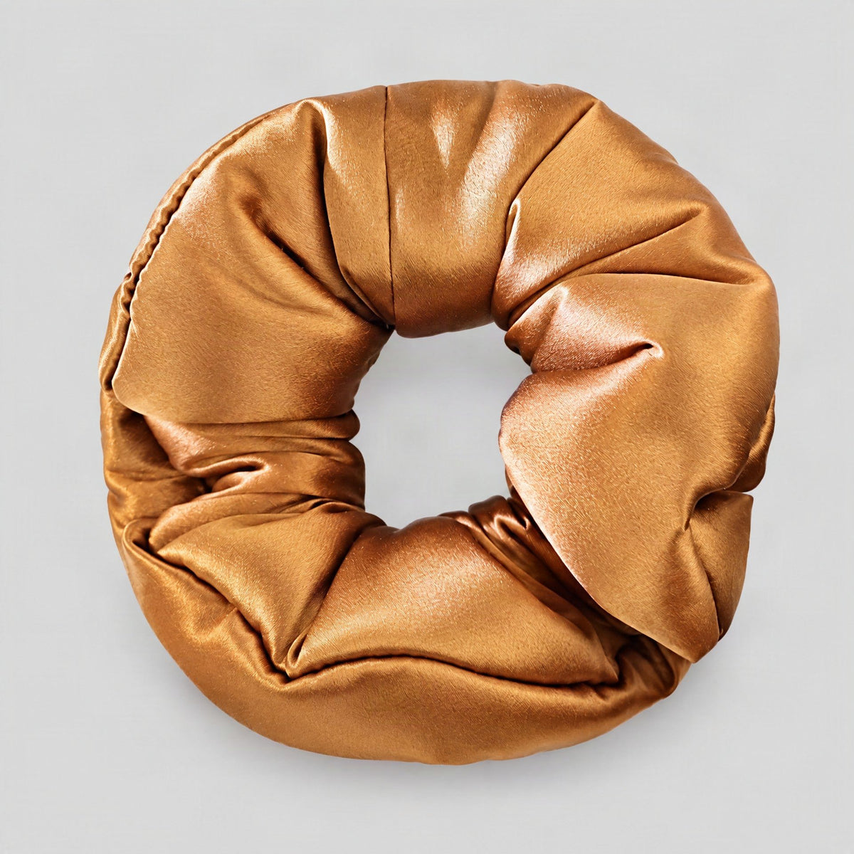 30 Momme silk scrunchie rests softly on a light surface, its smooth mulberry silk sheen catching gentle light to highlight it