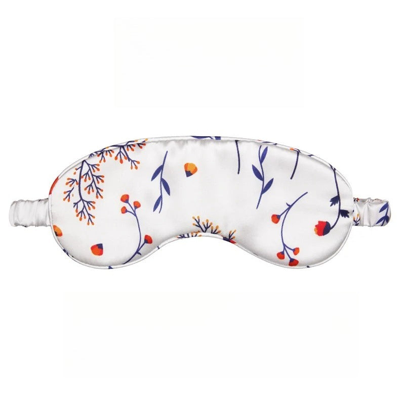 Mulberry silk sleep eye mask in soft blush pink, draped on a bedside table beside a warm cup of tea for a cozy nighttime sett