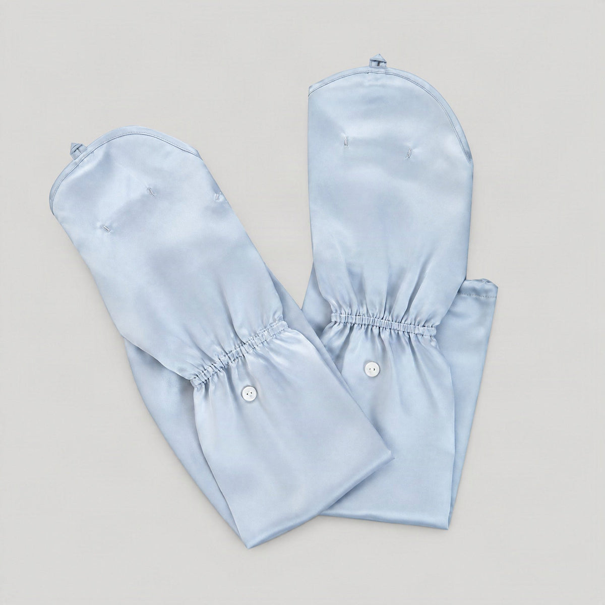 Pair of light blue mulberry silk UV arm sleeves with hand covers, laid flat