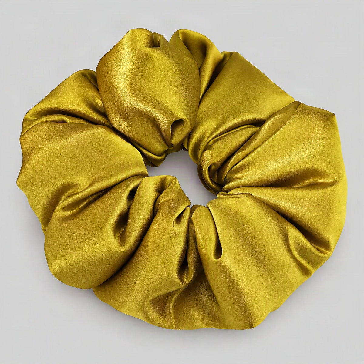 SuuSilk 30 Momme Padded Mulberry Silk Scrunchie in soft white, gently scrunched on a neutral surface
