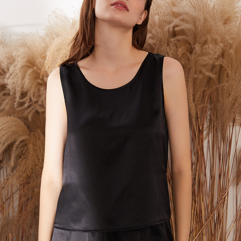Black silk tank top with a clean round neckline on model