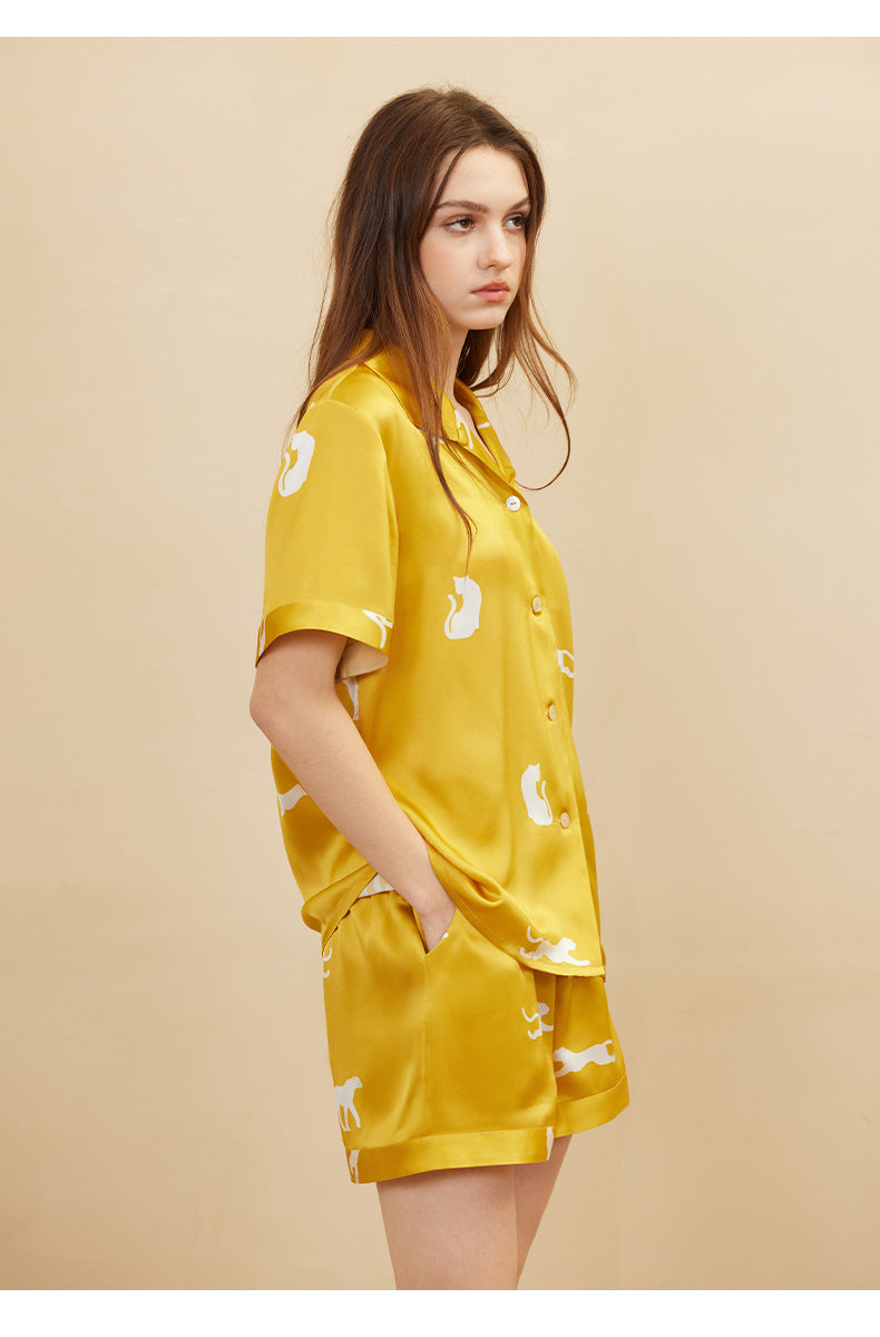 Flat lay of gold silk pajama set with folded shorts