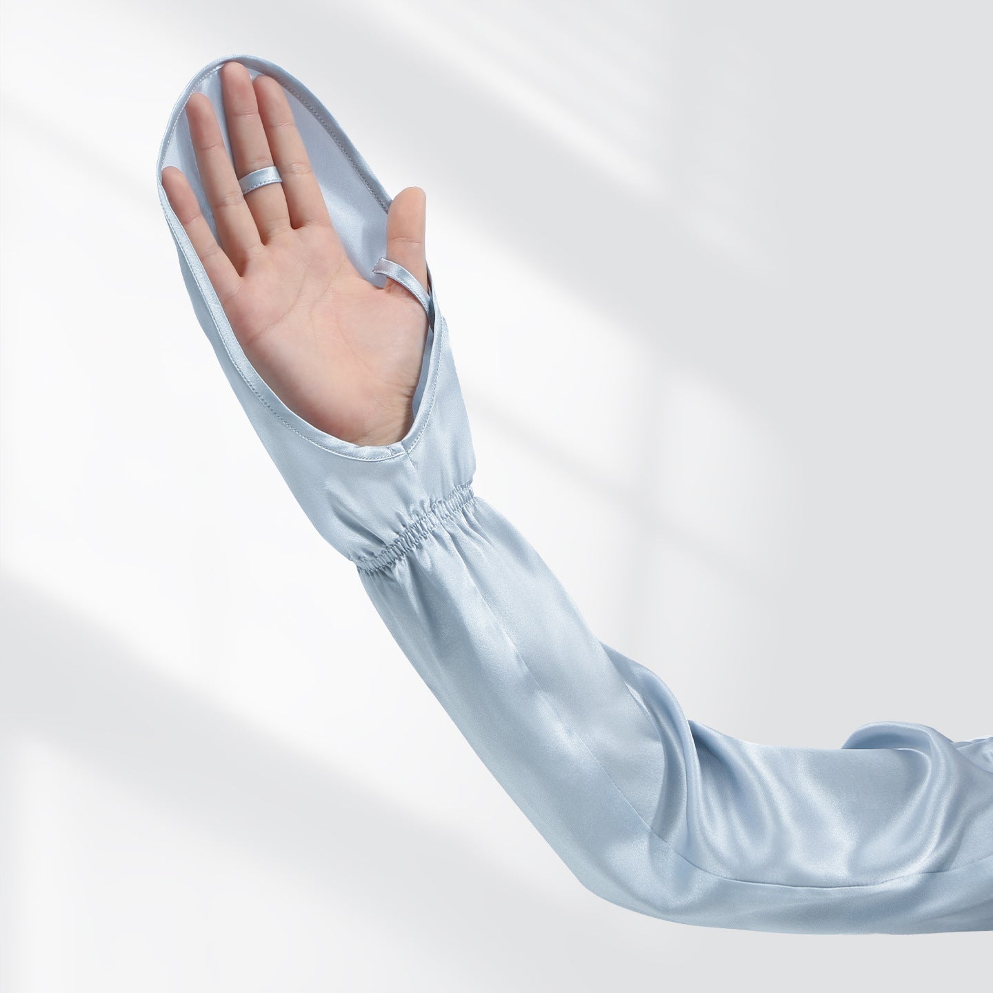 Model wearing gray-blue sleeves while driving, lifestyle shot