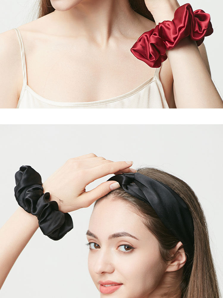 Black silk hair scrunchie on wrist and black silk headband worn by woman, side view