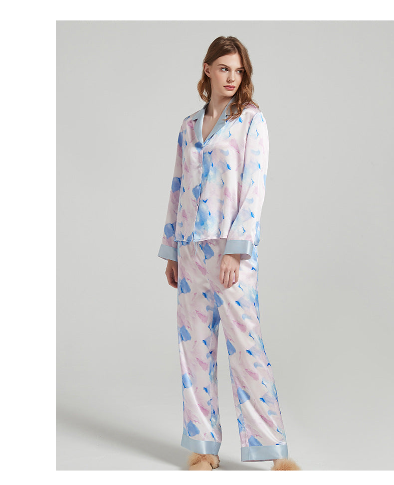 Lifestyle shot of the silk pajama set draped over a chair in a bedroom setting