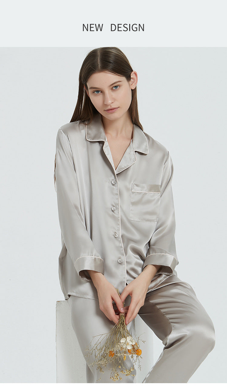 Model seated in light gray silk pajama set with dried flower bouquet