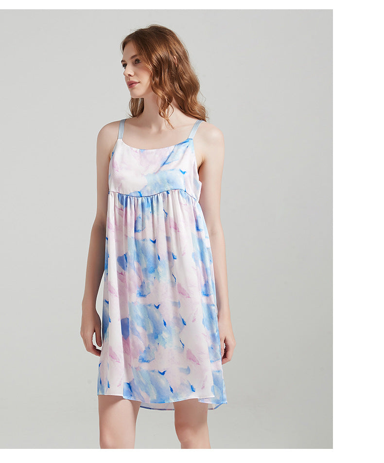 Lifestyle image of a woman lounging comfortably in the silk cami dress