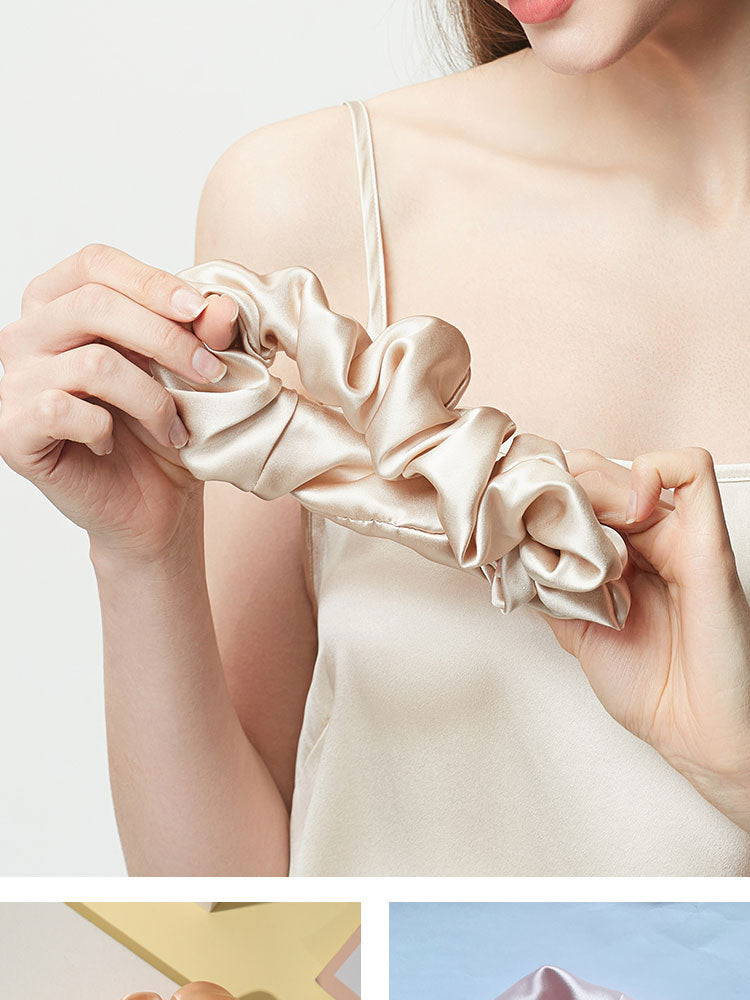 Champagne silk hair scrunchie held in hands, showing double-layer fabric folds