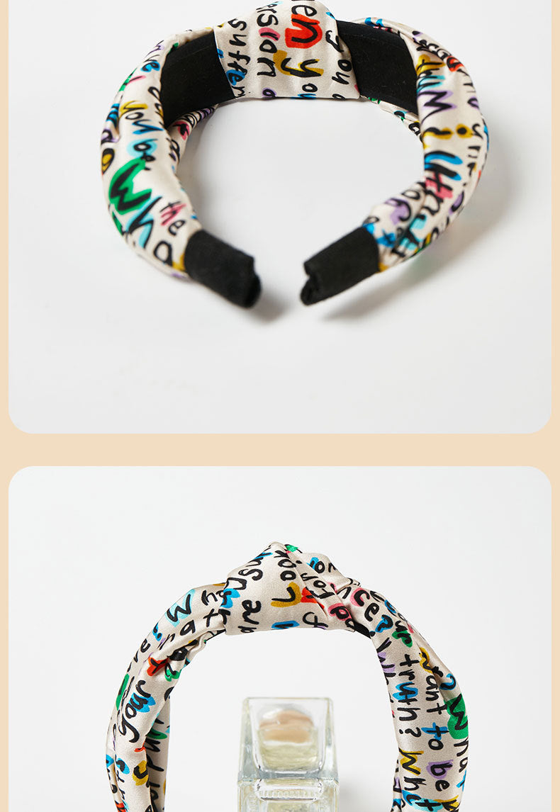 Side profile of the soft silk hair band displaying its flexible curve and print detail