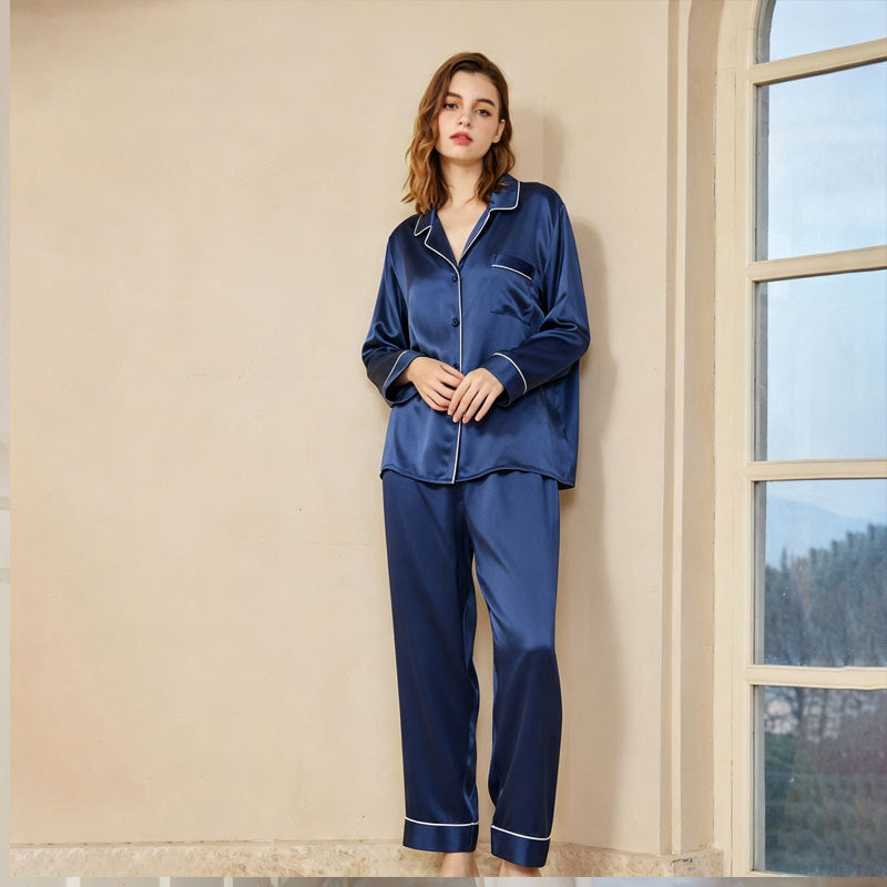 Side view of a woman wearing the silk pajama set while reading