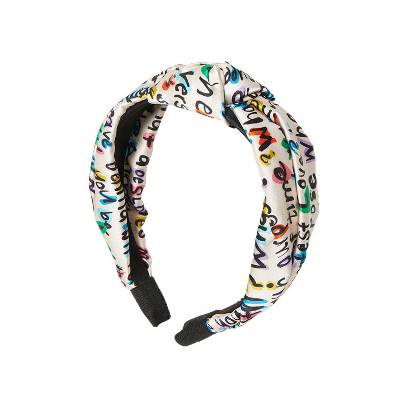 Mulberry silk headband with colorful letter print shown from the front on a white background