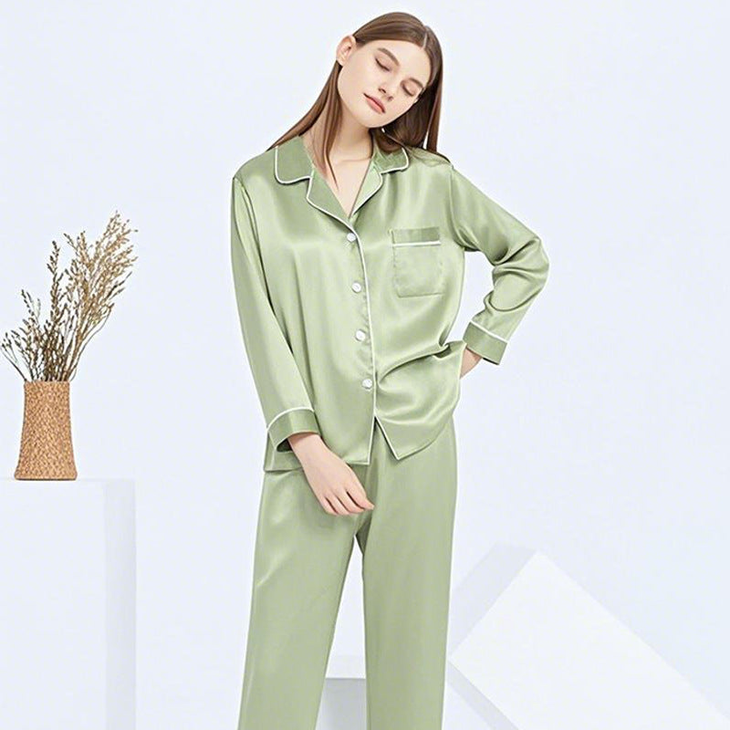 Model in sage green silk pajama set posed against a neutral backdrop