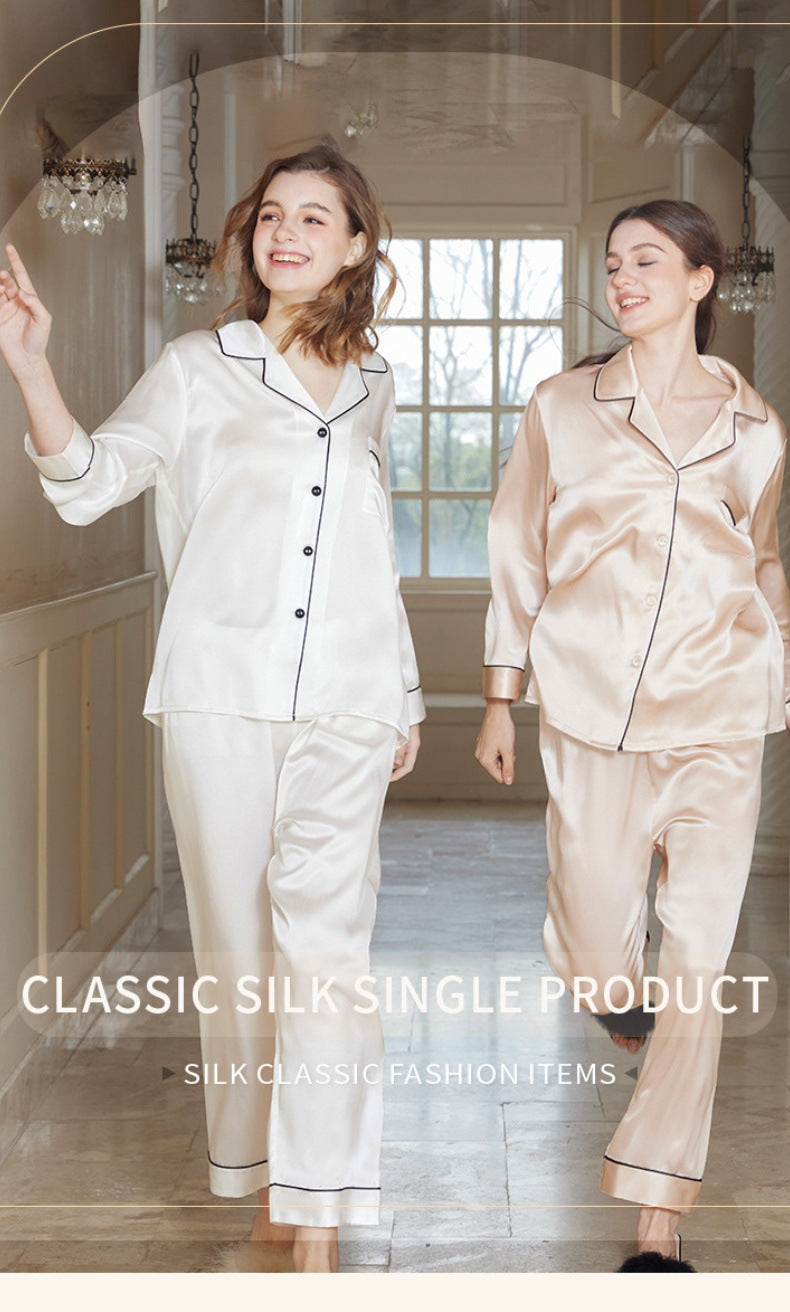 Lifestyle image of a woman lounging in silk pajamas with a cup of tea